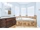 Bathroom featuring a soaking tub with tile accents, double vanity, and natural light at 6347 Ashley Dr, Lakeland, FL 33813
