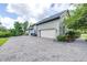 Long driveway leading to a large garage and parking area, bordered by lush landscaping and mature trees at 6347 Ashley Dr, Lakeland, FL 33813