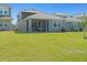 Wide backyard view with lush grass, trampoline, and a screened porch at 6520 Great Bear Dr, Lakeland, FL 33805