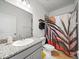 Well-lit bathroom features a granite countertop, modern sink, and colorful shower curtain at 6520 Great Bear Dr, Lakeland, FL 33805