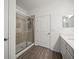 Bathroom featuring a glass-enclosed shower, wood-look flooring, and a white vanity with a solid surface countertop at 6520 Great Bear Dr, Lakeland, FL 33805