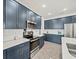 Modern kitchen features custom blue cabinets, stainless steel appliances and bright recessed lighting at 6520 Great Bear Dr, Lakeland, FL 33805