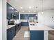 Modern kitchen features custom blue cabinets, quartz countertops, an island, and stainless appliances at 6520 Great Bear Dr, Lakeland, FL 33805