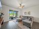 Comfortable living room with gray sectional sofa, ceiling fan, and sliding glass doors to the screened lanai at 6520 Great Bear Dr, Lakeland, FL 33805