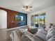 Cozy living room with ceiling fan, TV with wooden feature wall, comfortable seating, and screened-in lanai access at 6520 Great Bear Dr, Lakeland, FL 33805