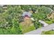 Aerial view showcases the property's extensive greenery, well-maintained lawn, and appealing curb appeal from above at 6735 Forestwood W Dr, Lakeland, FL 33811