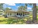Charming home exterior featuring a screened porch and ample backyard space on a sunny day with beautiful landscaping at 6735 Forestwood W Dr, Lakeland, FL 33811