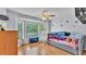 Bright bedroom featuring wood floors, a ceiling fan, and a large window at 6735 Forestwood W Dr, Lakeland, FL 33811