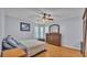 Relaxing bedroom featuring wood floors, soft lighting and a bay window overlooking the front yard at 6735 Forestwood W Dr, Lakeland, FL 33811