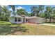A charming single-story home with a well-manicured lawn, inviting entrance, and an attached two-car garage at 6735 Forestwood W Dr, Lakeland, FL 33811