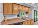 Close up of the kitchen featuring wood cabinets, and a tile counter with a stainless steel sink at 6735 Forestwood W Dr, Lakeland, FL 33811