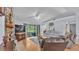 Comfortable living room featuring a stone fireplace, hardwood floors, and access to the screened lanai at 6735 Forestwood W Dr, Lakeland, FL 33811