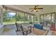 The Screened Porch is furnished with bench seating, table, and trunk, offering an idyllic view of the backyard at 6735 Forestwood W Dr, Lakeland, FL 33811