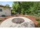 Landscaped backyard featuring a brick fire pit surrounded by wood mulch and various plants at 705 W Park St, Lakeland, FL 33803