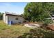 Landscaped backyard featuring a fire pit, shade trees, and a well-maintained lawn for outdoor enjoyment at 705 W Park St, Lakeland, FL 33803