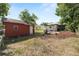 Expansive backyard featuring a storage shed, landscaping and partial views of adjacent homes at 705 W Park St, Lakeland, FL 33803