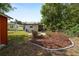 Large backyard with landscaped garden beds and fire pit, offering a serene outdoor living space at 705 W Park St, Lakeland, FL 33803
