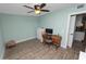 Bedroom featuring light green walls, wood-look flooring, computer desk, and a view to the kitchen at 705 W Park St, Lakeland, FL 33803