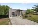 Modern home featuring a front patio, xeriscape landscaping and a brick paver driveway at 705 W Park St, Lakeland, FL 33803
