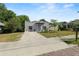 Cozy one-story house with a brick driveway, minimalist landscaping, and a vibrant blue front door at 705 W Park St, Lakeland, FL 33803