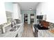 Galley kitchen featuring white cabinets, stone countertops, stainless steel appliances, and in-unit washer/dryer at 705 W Park St, Lakeland, FL 33803