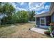A backyard featuring a partially screened-in patio, a white fence, and numerous trees at 7088 Remington Oaks Loop, Lakeland, FL 33810