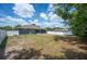 Expansive backyard featuring a screened-in patio and a white picket fence, perfect for outdoor activities at 7088 Remington Oaks Loop, Lakeland, FL 33810