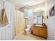 A bathroom featuring a vanity, a toilet, a shower/tub with a patterned curtain, and a small window at 7088 Remington Oaks Loop, Lakeland, FL 33810