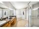 Well-lit bathroom with double sinks, soaking tub, glass enclosed shower, and tile floors at 7088 Remington Oaks Loop, Lakeland, FL 33810
