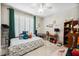A bedroom featuring a bed with various throw pillows, a ceiling fan, and a writing desk at 7088 Remington Oaks Loop, Lakeland, FL 33810