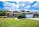 Charming home with a well-kept lawn, a two-car garage, and a welcoming front entrance at 7088 Remington Oaks Loop, Lakeland, FL 33810
