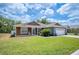 Beautiful home featuring a well-manicured lawn, wood accents, and an attached two-car garage at 7088 Remington Oaks Loop, Lakeland, FL 33810