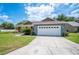 Home showcasing a lush green lawn, an attached two-car garage, and a well-maintained driveway at 7088 Remington Oaks Loop, Lakeland, FL 33810