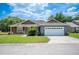 Well-maintained home with a two-car garage, manicured lawn, and inviting front porch at 7088 Remington Oaks Loop, Lakeland, FL 33810