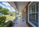 Charming covered front porch with wood paneling, white columns, rocking chair, and a welcoming entrance at 7088 Remington Oaks Loop, Lakeland, FL 33810