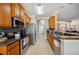 Well-lit kitchen features wood cabinets, stainless steel appliances, and a breakfast bar at 7088 Remington Oaks Loop, Lakeland, FL 33810