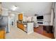 Open-concept kitchen with stainless steel appliances, hardwood floors, and a view into the living room at 7088 Remington Oaks Loop, Lakeland, FL 33810