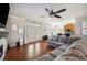 Bright living room with hardwood floors, a comfortable sofa, and an open layout to the kitchen at 7088 Remington Oaks Loop, Lakeland, FL 33810