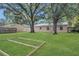 Backyard with a metal roof shed, wooden frame, and mature trees at 7208 Thomas Jefferson Cir, Bartow, FL 33830