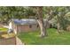 View of backyard with lush grass, mature trees, and a newly built fence at 7208 Thomas Jefferson Cir, Bartow, FL 33830
