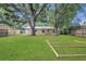 Lush backyard featuring a wooden shed, wooden frame, and large trees at 7208 Thomas Jefferson Cir, Bartow, FL 33830