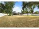 Spacious backyard showcasing lush trees and a white fence, offering a serene outdoor retreat and privacy at 781 Bryson Loop, Lakeland, FL 33809