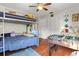 Bright bedroom with hardwood floors, a ceiling fan, a bunk bed and play area, and built-in storage and decor at 781 Bryson Loop, Lakeland, FL 33809