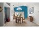 Sunlit dining area features a large wood table, blue accent wall, and view of the backyard at 781 Bryson Loop, Lakeland, FL 33809
