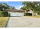 Spacious driveway leading to a two-car garage, set against a backdrop of mature landscaping at 781 Bryson Loop, Lakeland, FL 33809