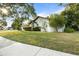 Well-maintained white single-story house with a green lawn and lush, mature trees at 781 Bryson Loop, Lakeland, FL 33809