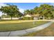 Landscaped front yard with green grass and mature trees surrounding a white single story home at 781 Bryson Loop, Lakeland, FL 33809
