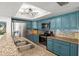 Granite countertops and stainless appliances accent the bright kitchen with blue cabinets at 781 Bryson Loop, Lakeland, FL 33809