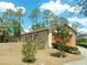 Back exterior with a well-maintained lawn, mature trees, and a cozy backyard at 7952 Grand Pines Blvd, Lakeland, FL 33810