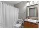 Cozy bathroom with decorative mirror, white fixtures, and shower with curtain at 7952 Grand Pines Blvd, Lakeland, FL 33810